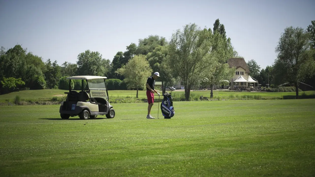 Buggy and golfers on the fairway at Golf de Beaune Levernois